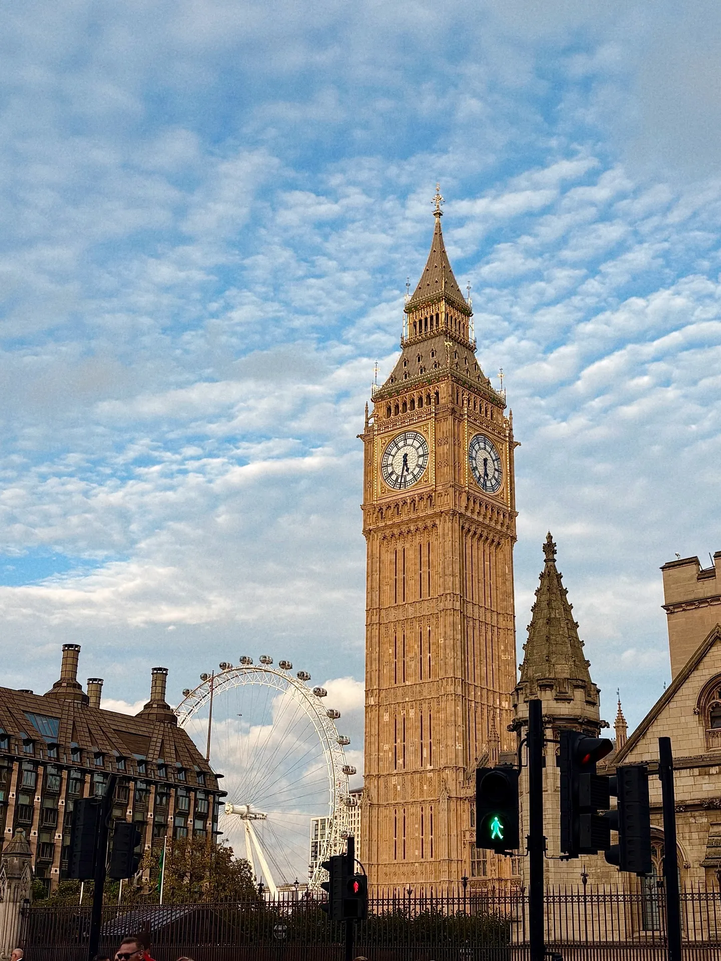 Tháp đồng hồ Big Ben và vòng quay London Eye dưới bầu trời mây xanh tại Anh.