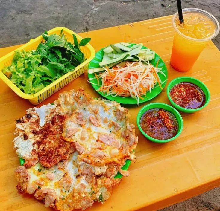 Đĩa bánh ép Huế nóng giòn với nhân thịt, trứng, rau sống và nước chấm chua ngọt